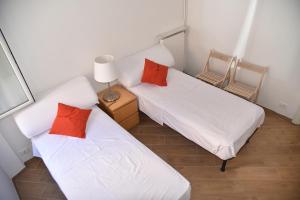 2 camas en una habitación con 2 sillas y una lámpara en Spiaggia e Gaslini, en Génova