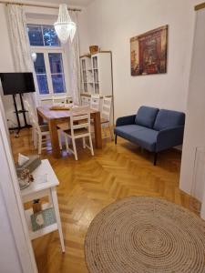 sala de estar con sofá azul y mesa en Entzückendes Apartment im Zentrum, en Graz