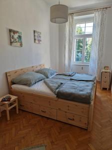 1 dormitorio con cama grande de madera frente a una ventana en Entzückendes Apartment im Zentrum, en Graz