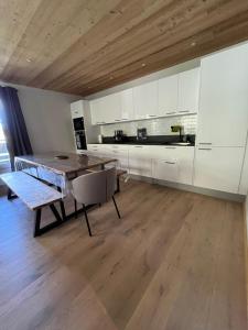 a kitchen with white cabinets and a wooden ceiling at Arc 1950 Ap 171 Résidence les Sources de Marie in Bourg-Saint-Maurice