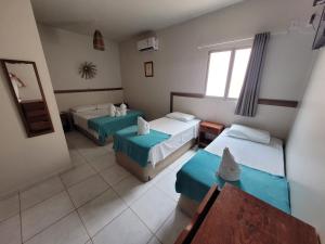 um quarto de hotel com duas camas e um espelho em Pousada Tartaruga em Maragogi