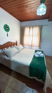 1 dormitorio con 1 cama grande y ventana en Pousada Casa D'Antonia, en Campos do Jordão