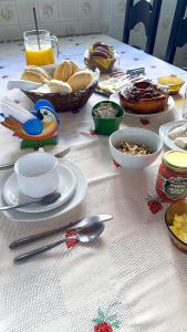 una mesa con platos y tazones de comida. en Pousada Casa D'Antonia, en Campos do Jordão