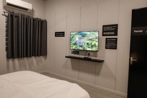 a room with a bed and a tv on a wall at FAST FIVE At Gurney in Tanjong Tokong