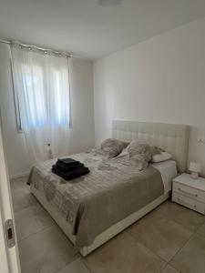 ein weißes Schlafzimmer mit einem großen Bett und einem Fenster in der Unterkunft Ulisse Palace in Lido di Jesolo