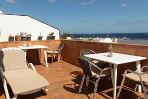 een patio met tafels en stoelen op een dak bij Hostal Magec in Puerto del Carmen