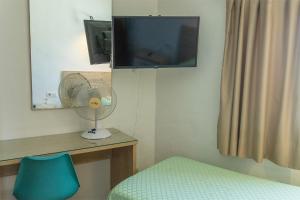 a room with a fan and a tv and a bed at Hostal Magec in Puerto del Carmen