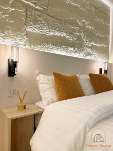 1 dormitorio con 1 cama con sábanas y almohadas blancas en Modern studio with self check-in, en Riad