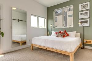 a bedroom with a large white bed and a mirror at Modern Denver Townhome with Rooftop Terrace! in Denver