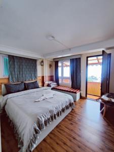 a bedroom with a large bed with blue curtains at Mandala Fram Stay in Darjeeling