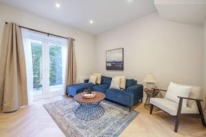 a living room with a blue couch and a table at Cosy Tooting Retreat: 2-Bed Gem in London