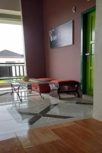 ein Wohnzimmer mit einem Tisch und einer grünen Tür in der Unterkunft OYO 93088 Celine Home Syariah in Parit