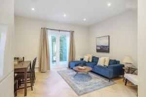 倫敦的住宿－Cosy Tooting Retreat: 2-Bed Gem，客厅配有蓝色的沙发和桌子