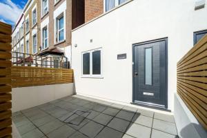 an empty courtyard with a black door on a building at Cosy Tooting Retreat: 2-Bed Gem in London
