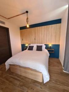 a bedroom with a large white bed with blue walls at Wonderful Rooftop - 6 pers - Nice in Saint-Laurent-du-Var