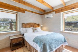 a bedroom with a bed and two windows at Adobe Vista in Alpine