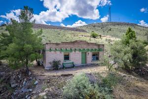 an old brick building with a green door on a hill at Adobe Vista in Alpine