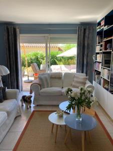 a living room with a white couch and tables and a dog at La Batie Saint-André in Redessan