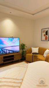 uma sala de estar com uma televisão de ecrã plano e um sofá em Modern studio with self check-in em Riyadh