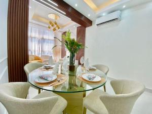 uma sala de jantar com uma mesa de vidro e cadeiras em Elegant City Center Condo em Santo Domingo