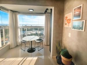 a dining room with a table and a large window at PALMAS EXPERIENCE - APARTAMENTO VISTA LAGO, próximo ao shopping in Palmas