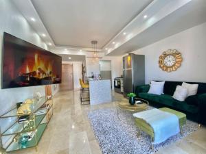 a living room with a green couch and a fireplace at Great Centric Apt, Pool, in Santo Domingo