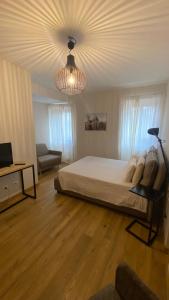 a bedroom with a large bed and a chandelier at I giardini del borgo in Vico nel Lazio