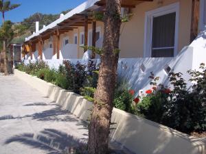 a tree in front of a building with flowers at Joanna Studios in Plakias