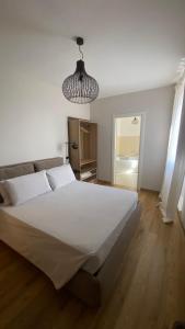 een slaapkamer met een groot wit bed en een kroonluchter bij I giardini del borgo in Vico nel Lazio