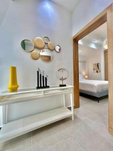 a bedroom with a bed and a table with mirrors at Stunning City Center Condo in Los Prados