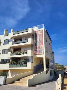 un gran edificio blanco con escaleras delante en Apartamento familiar Praia Barra, en Praia da Barra