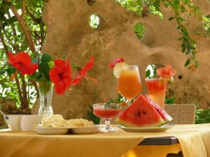 einen Tisch mit Speisen und Getränken auf einem Tisch mit Blumen in der Unterkunft Alba D'Amore Hotel & Spa in Lampedusa