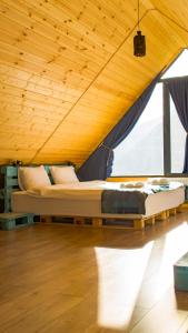 a bed in a room with a wooden ceiling at Cliffside cottage Kazbegi in Stepantsminda