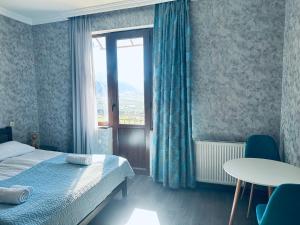 a bedroom with a bed and a table and a window at Nikolo Inn in Stepantsminda