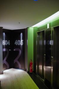 a room with green and black walls and a elevator at Hotel Black Inn Flamboyant in Goiânia