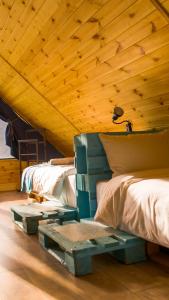 a room with two beds and a wooden ceiling at Cliffside cottage Kazbegi in Kazbegi +10 photos