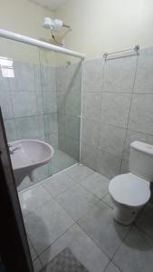 uma casa de banho com um chuveiro, um WC e um lavatório. em Rioli quarto 2 em Caruaru