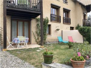 un patio avec des chaises et une table devant un bâtiment dans l'établissement Charmant 2 pièces avec parking et Wi-Fi à Saint-Chaffrey - FR-1-762-46, à Saint-Chaffrey