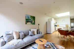 uma sala de estar com um sofá e uma mesa em Eden-Stay like locals in Fitzroy North em Melbourne