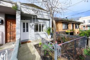 uma casa com uma porta branca e uma cerca em Eden-Stay like locals in Fitzroy North em Melbourne