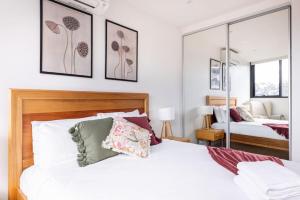 - une chambre avec un lit blanc et un miroir dans l'établissement Sanctuary-Effortless City Escape, à Melbourne