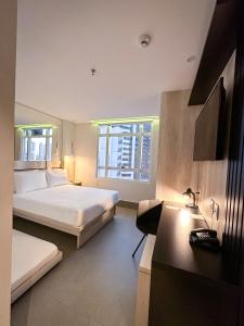 a hotel room with two beds and a desk at Hotel Black Inn Flamboyant in Goiânia +44 photos