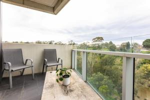 d'un balcon avec deux chaises et une table. dans l'établissement Sanctuary-Effortless City Escape, à Melbourne