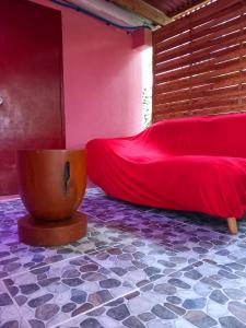 um quarto com uma cama vermelha e um lençol vermelho em Bora Rent lodge em Bora Bora