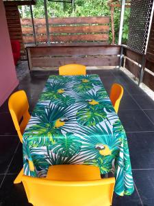 a table with yellow chairs with a colorful table cloth at Bora Rent lodge in Bora Bora