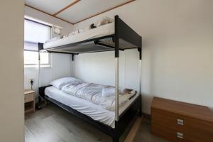 sypialnia z 2 łóżkami piętrowymi w pokoju w obiekcie 26, gelegen in het bosrijke Oisterwijk met privé tuin! w mieście Oisterwijk