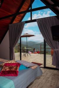 a bedroom with a bed and a view of a deck at Glamping San Pedro in San Gil