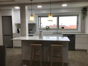 a kitchen with a large white island with bar stools at Oceanview Apartments in Viana do Castelo