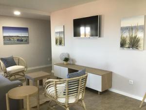 a living room with a couch and a tv on the wall at Oceanview Apartments in Viana do Castelo