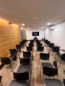una sala de conferencias con sillas y una pantalla de proyección en Hotel Black Inn Flamboyant, en Goiânia